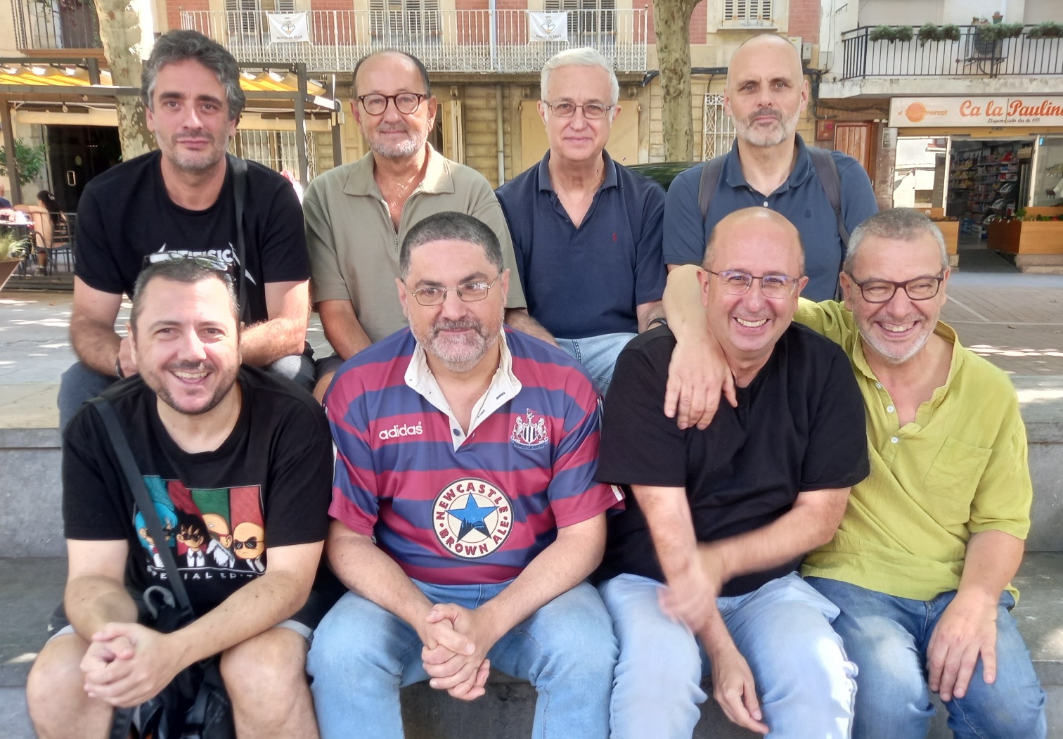 Grupo de personas sentadas posando para una foto El contenido generado por IA puede ser incorrecto.